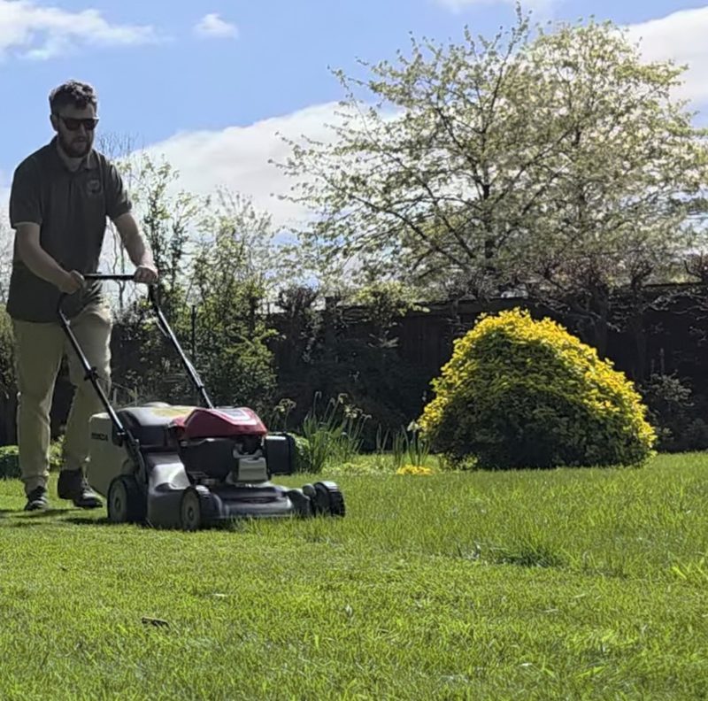 Cam mowing a customer's lawn on a sunny day
